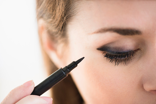 Gettyimages USA, New Jersey, Jersey City, Young woman applying eyeliner -фото