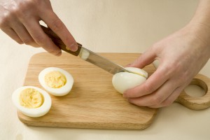 Разрезание отваренного вкрутую яйца пополам - фото
