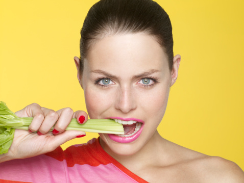 Девушка ест сельдерей - фото