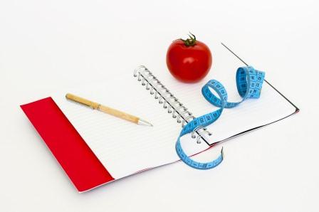 Блокнот, ручка, сантиметр та яблуко
