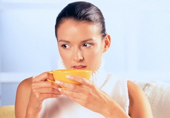 Женщина пьет чай из калины - фото