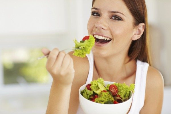 Женщина ест салат - фото