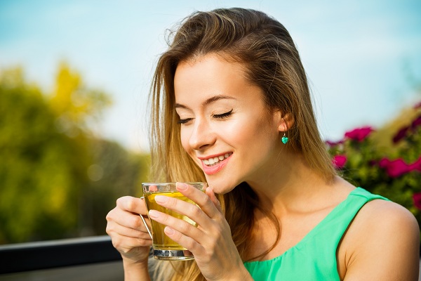 молодая женщина пьет зеленый чай