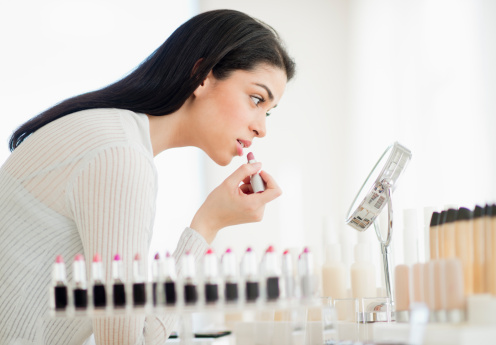 USA, New Jersey, Jersey City, Young woman applying lipstick - фото