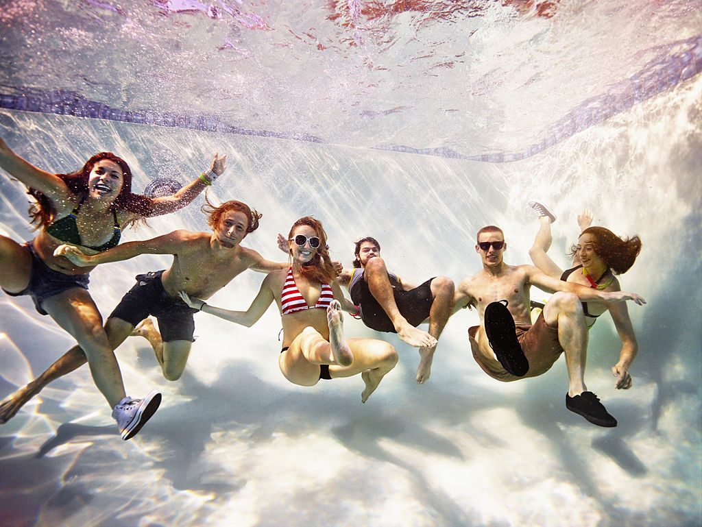 Group of friends embracing underwater - фото