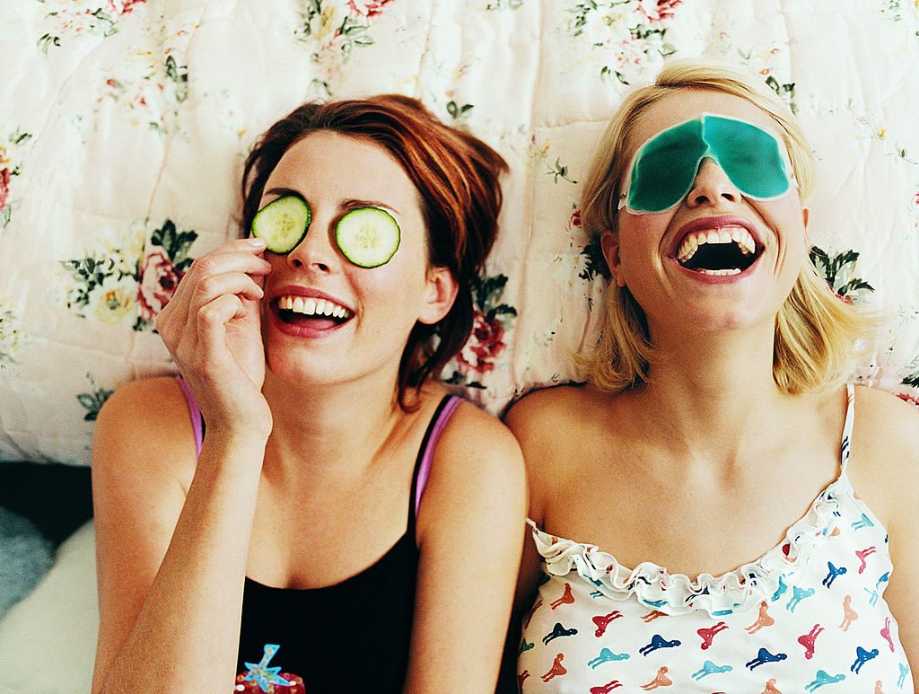 Two Female Teenagers Lying in Bed Wearing Eye Masks - фото