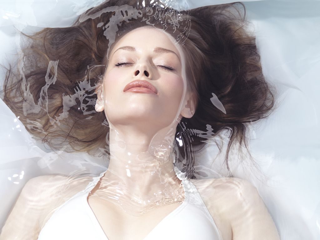 Natural look beauty portrait of a young woman lying relaxed in water with closed eyes Beauty treatment concept -фото