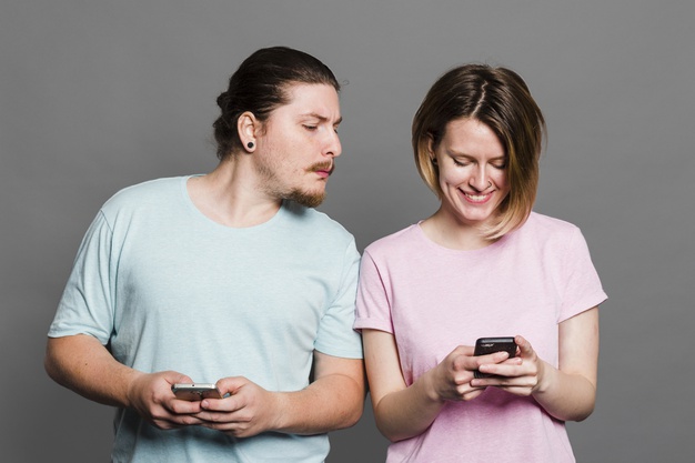 young-man-spying-peeking-smartphone-her-girlfriend-using-mobile-phone_23-2148179639