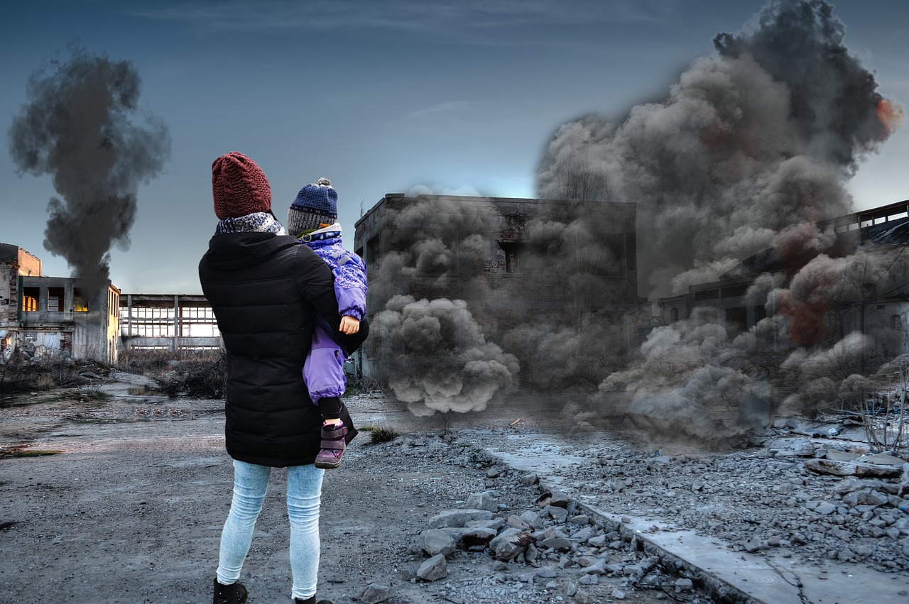 Дівчина з дитиною дивиться на знищений дім