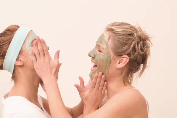 Two laughing young women with face masks